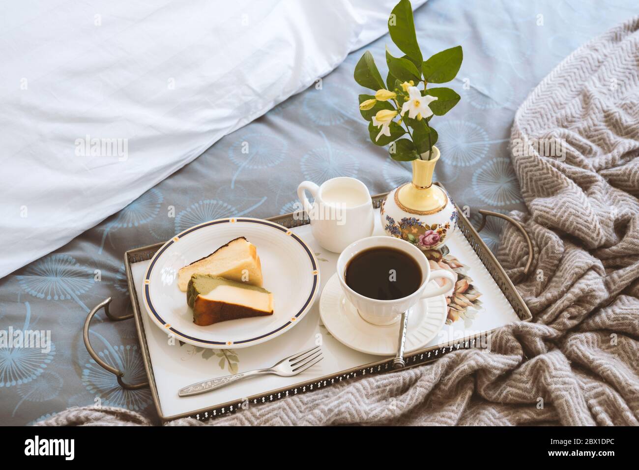 Frühstück im Bett Scheibe Cheesesescake mit einer Tasse Kaffee und Blumen in einem Tablett Stockfoto