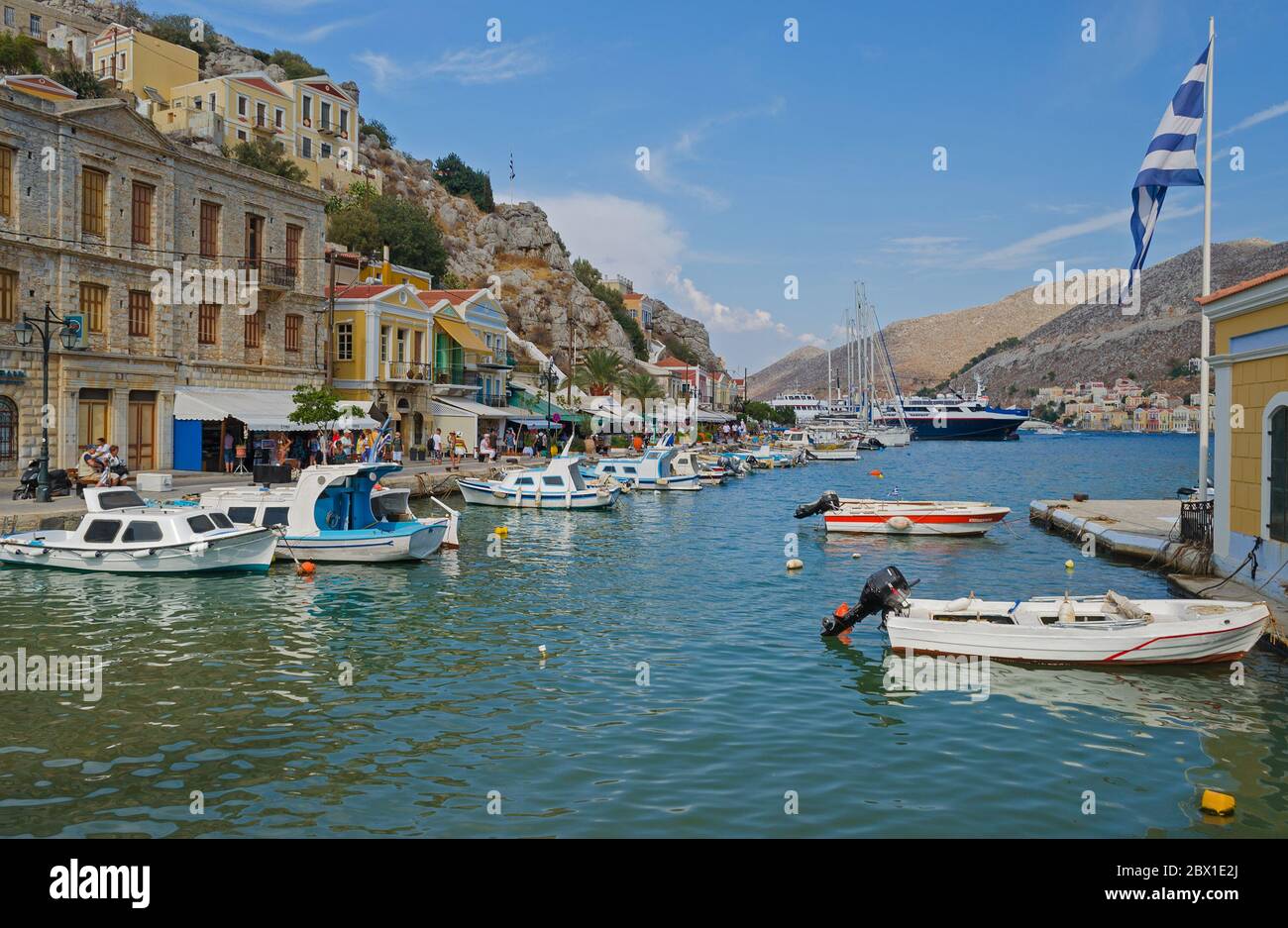 Symi Hafen mit neoklassizistischen Gebäuden und Fischerbooten Stockfoto
