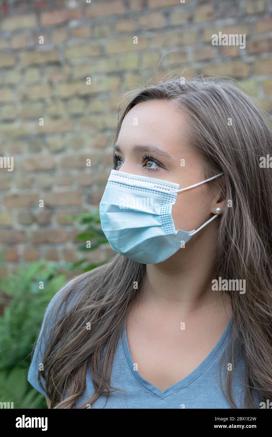 Portrait der jungen kaukasischen Frau mit Schutzmaske im Gesicht, Schutz vor Viren und Krankheiten. Stockfoto