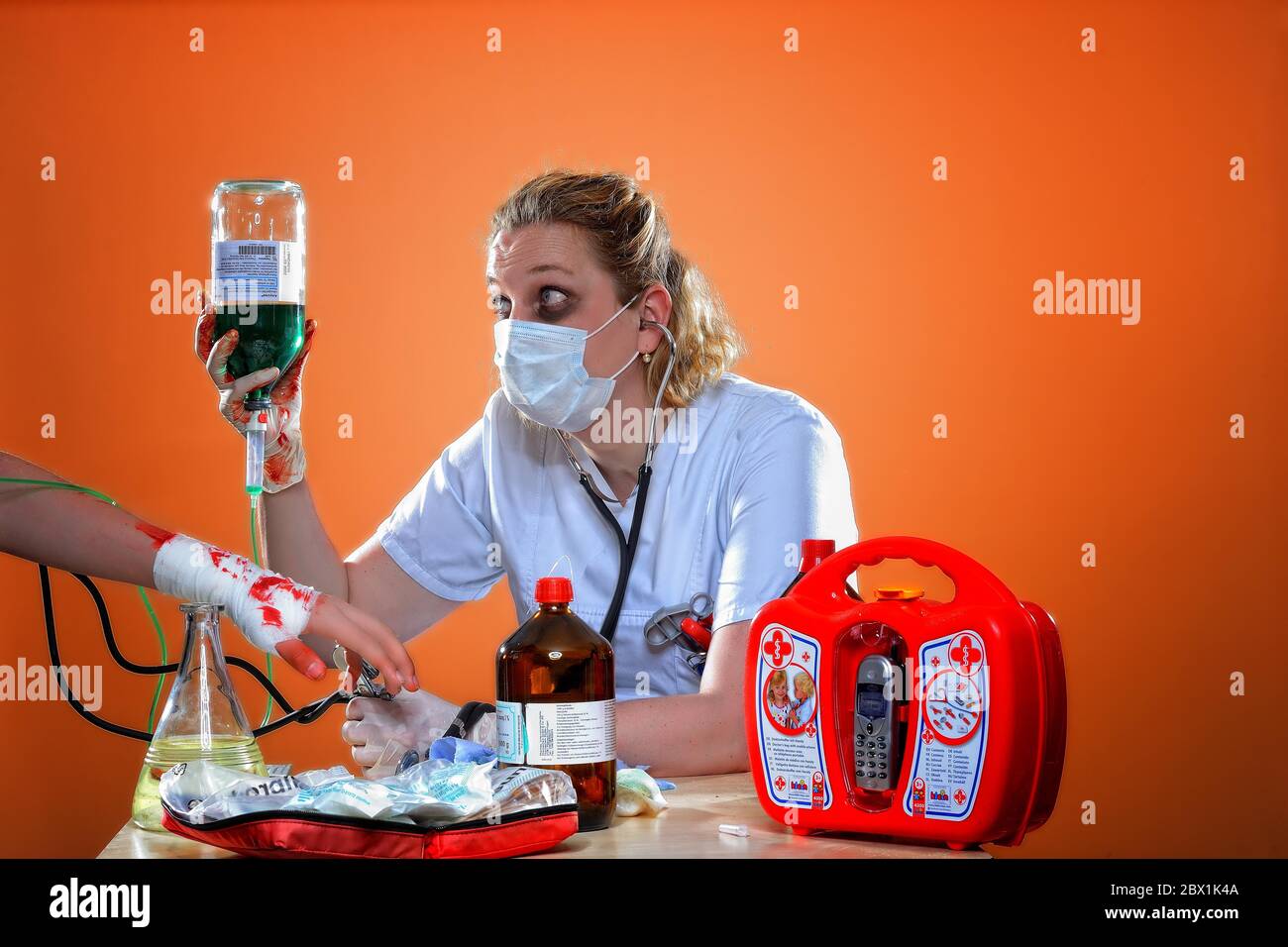 Erschöpfte Krankenschwester, Patient mit bandagierten Handgelenk bekommt Infusion, Deutschland Stockfoto