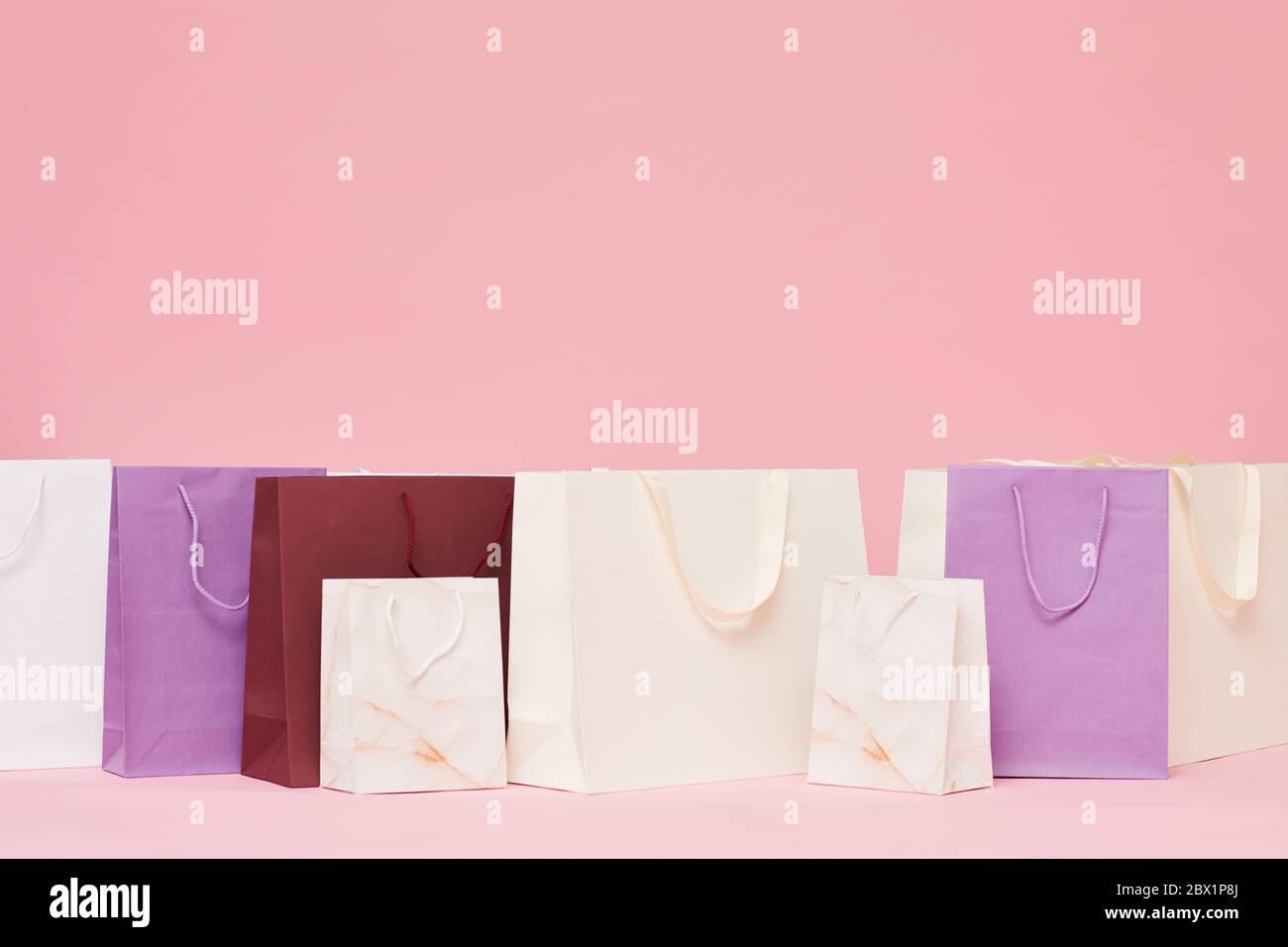 Bild von verschiedenen Einkaufspapiertaschen isoliert auf rosa Hintergrund Stockfoto