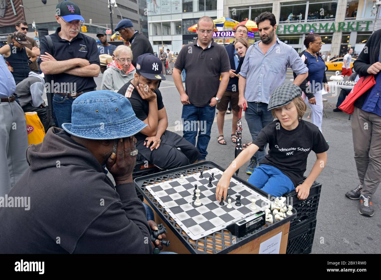 Ein junger Mann zieht eine Menge und spielt Schach gegen einen älteren Mann. Im Union Square Park. Stockfoto