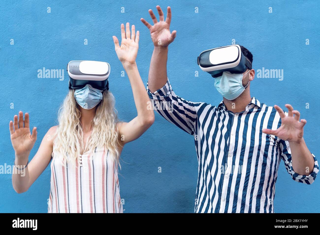 Junges Paar trägt Gesicht chirurgische Maske Spaß mit Virtual Reality Brille während Ausbruch Stockfoto