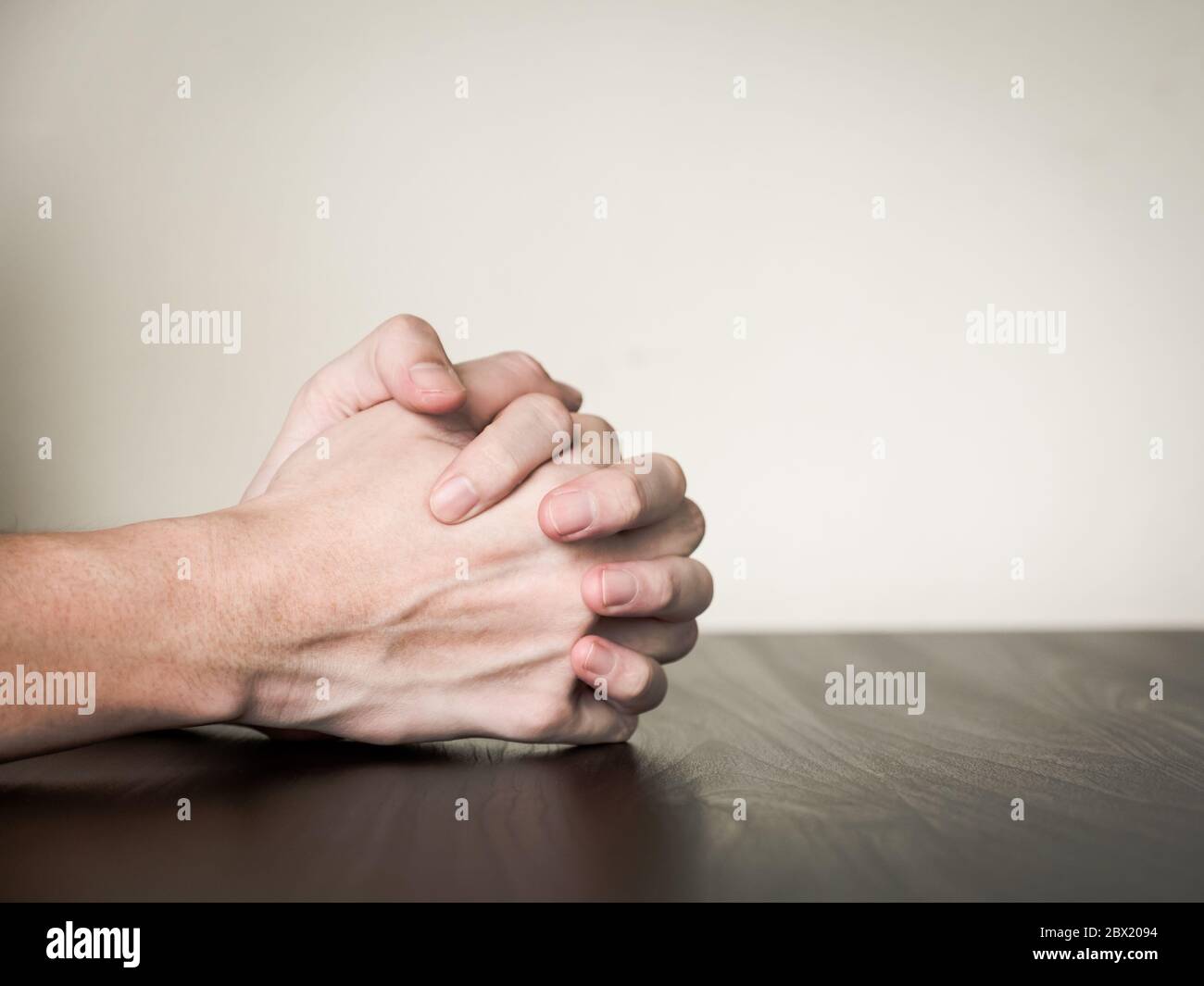 Hände gefaltet auf dem Tisch zusammen, beten Konzept Stockfoto