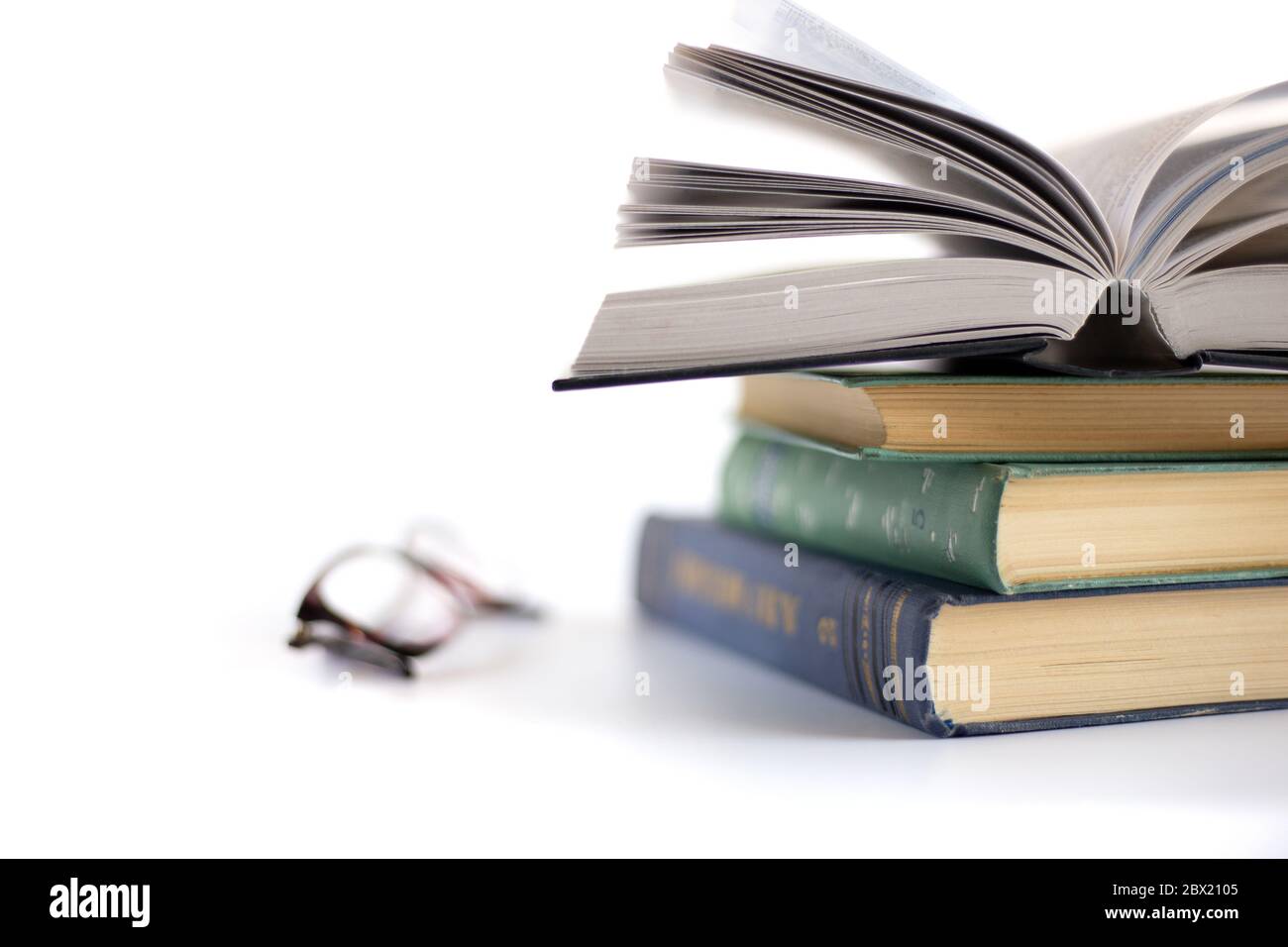 Offenes Buch auf dem Haufen alter Bücher und Lesebrille auf weißem Hintergrund. Zeit weg von der Technologie. Finden ruhigen Ort, um das Gehirn zu beruhigen. Stockfoto Offenes Buch auf dem Haufen alter Bücher und Lesebrille auf weißem Hintergrund. Zeit weg von der Technologie. Finden ruhigen Ort, um das Gehirn zu beruhigen. Stockfoto