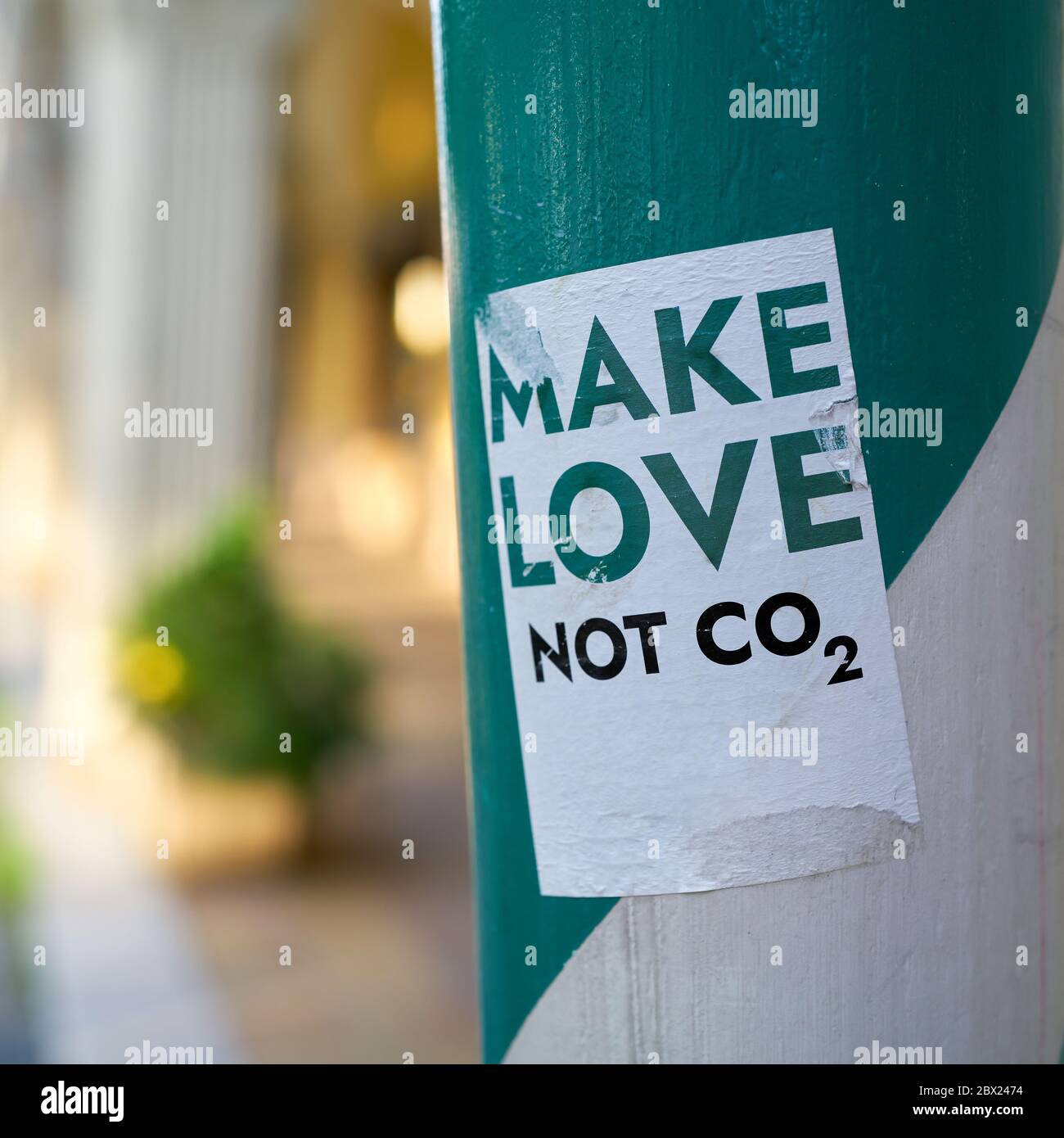 Aufkleber auf einer Säule in der Berliner Innenstadt mit der Aufschrift Make love not co2 Stockfoto
