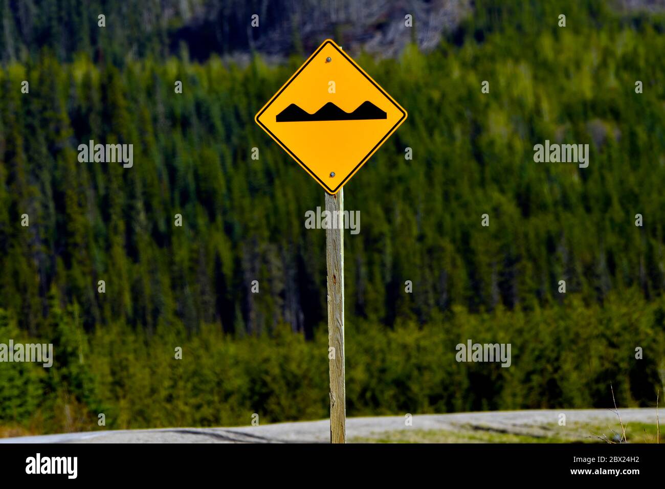 Ein Bump-Schild auf der Straße warnt den Autofahrer, dass es eine Bump auf der entgegenkommenden Straße Stockfoto