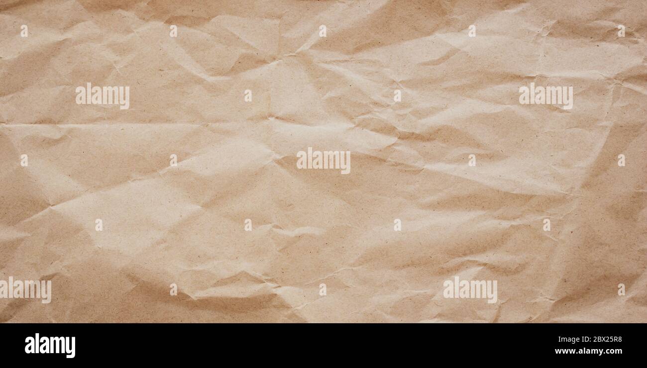 Zerknitterte braune Papierstruktur, Hintergrund. Unordentlich faltiges Pergamentmuster. Bastelpapier rustikal, alte Geschenkkarte Stockfoto