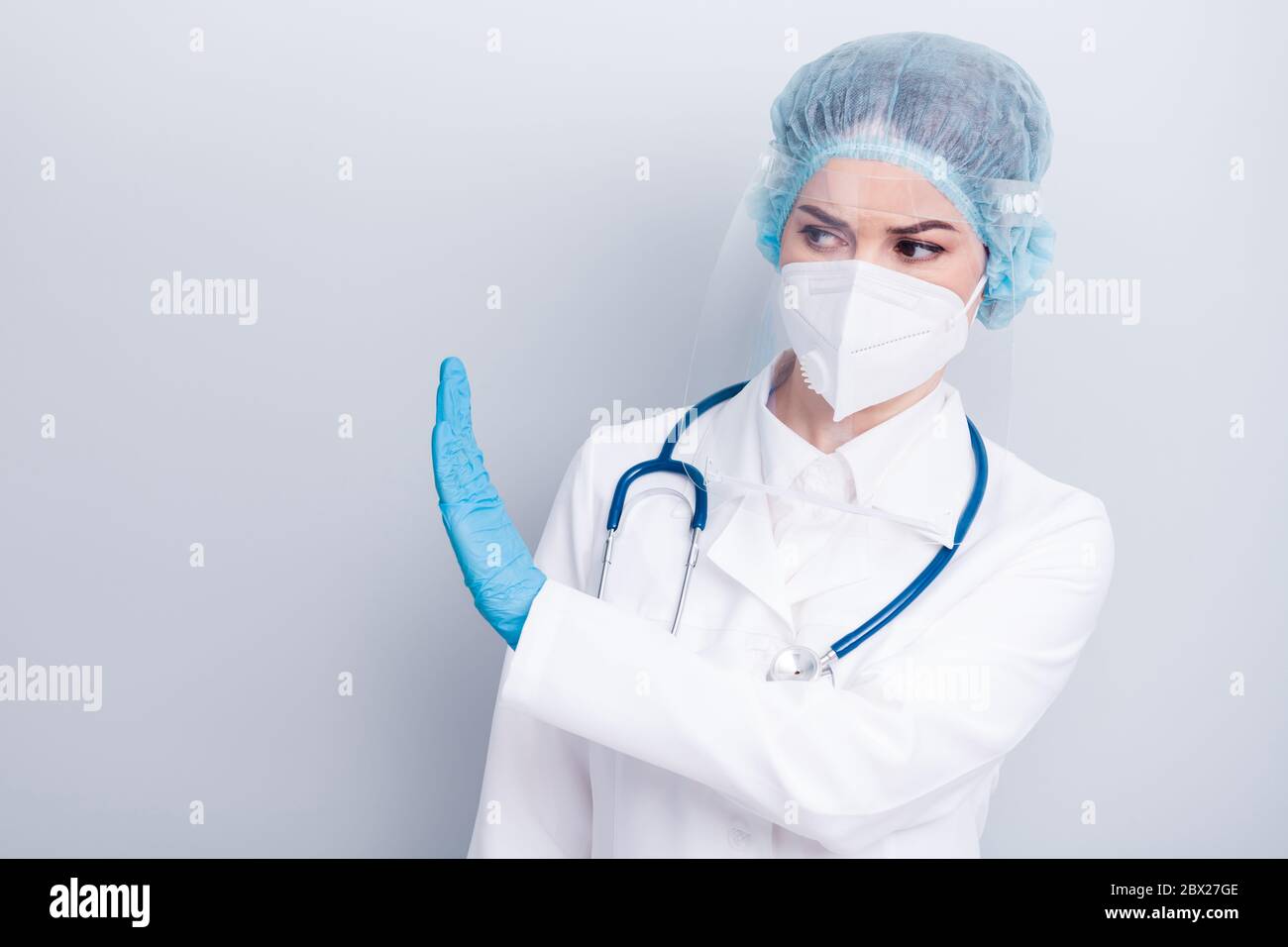 Foto von schönen Dame doc heben Palmseite bleiben weg von covid gefährlich infiziert experimentelle Zone tragen Handschuhe Maske Mantel Gesichts Kunststoff chirurgisch Stockfoto