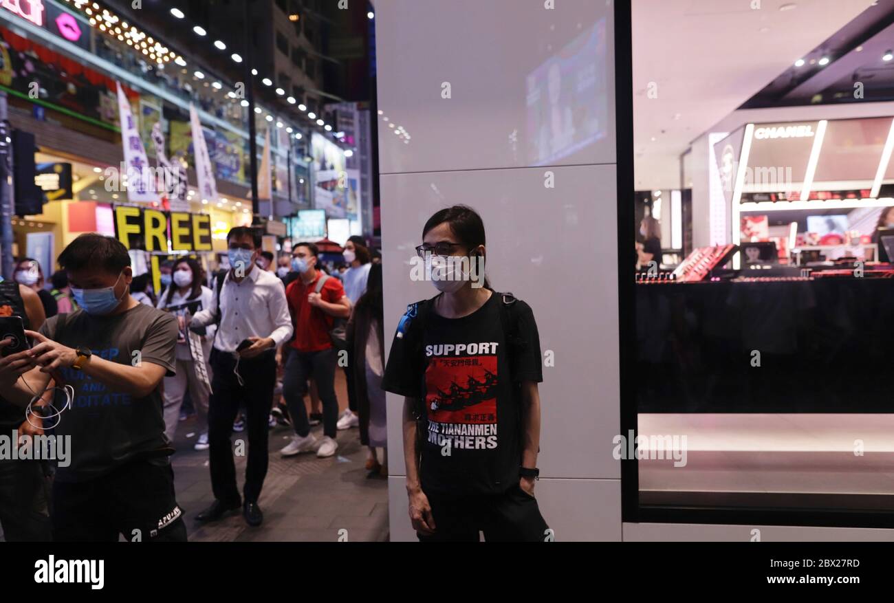 Hongkong, CHINA. Juni 2020. Ein Mann, der ein T-Shirt mit protestierendem politischen Slogan trägt, steht am Abend des 31. Jahrestages des 4. JUNI-Massakers von Tian an an Men in der Causeway Bay außerhalb des Victoria Parks, einem traditionellen Veranstaltungsort für die jährliche Kerzenlichtvigil.4. Juni 2020 Hongkong.ZUMA/Liau Chung-ren Quelle: Liau Chung-ren/ZUMA Wire/Alamy Live News Stockfoto