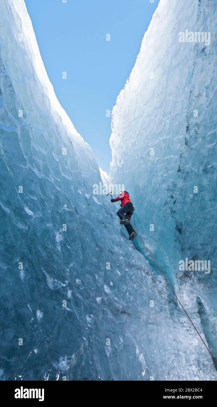 Frau klettert aus der Gletscherhöhle / SÃ³lheimajÃ¶Kull Gletscher hinein Island Stockfoto