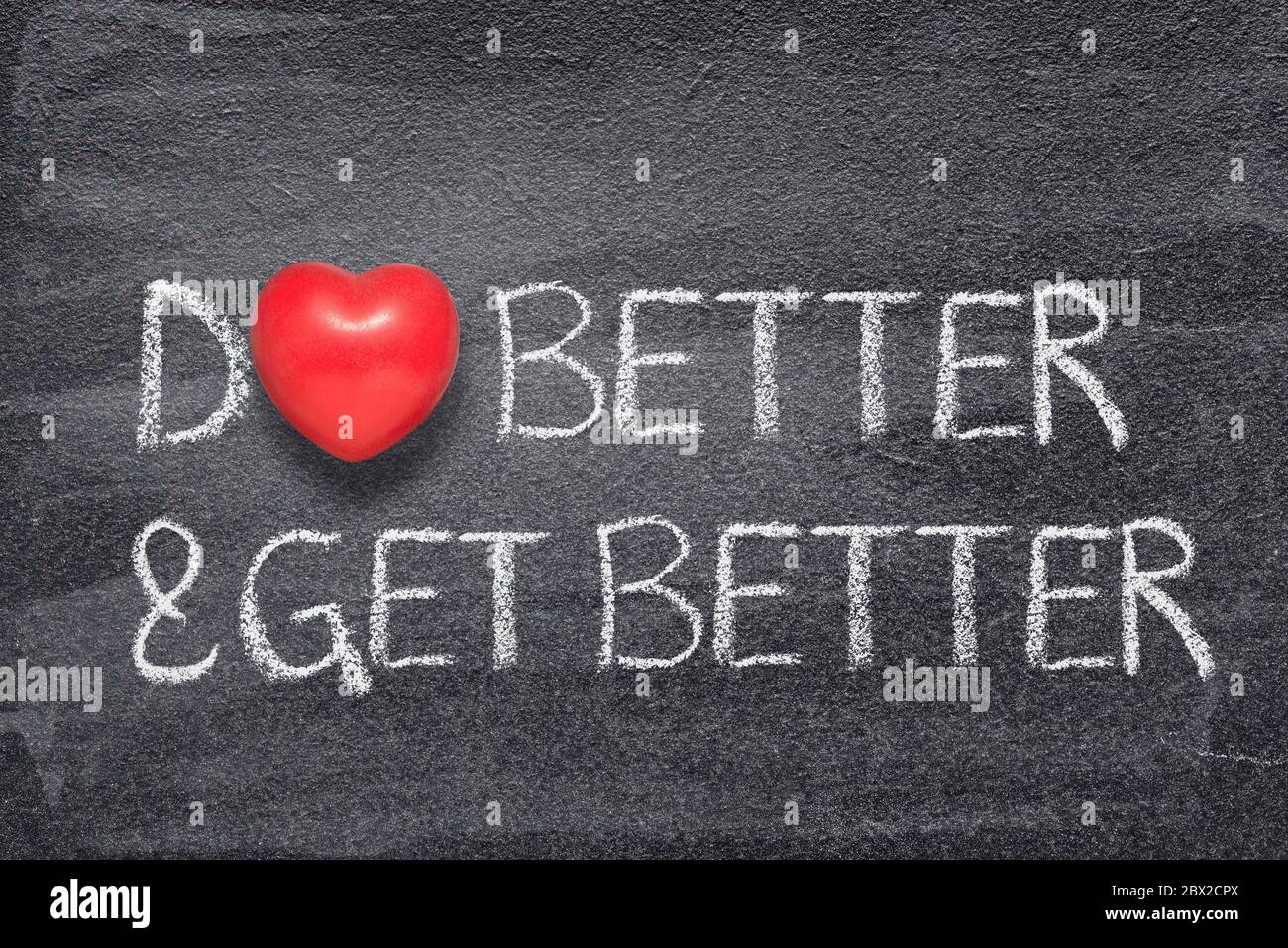 Besser machen und besser Phrase auf Tafel mit rotem Herz-Symbol geschrieben Stockfoto