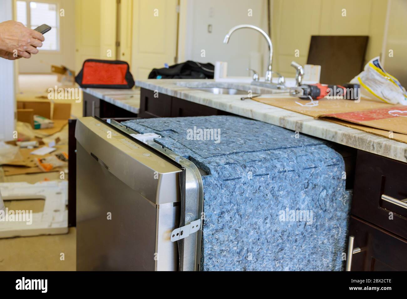 Handwerker in der Nähe Werkzeuge Ausrüstung Reparatur Geschirrspüler Maschine in der Küche Stockfoto