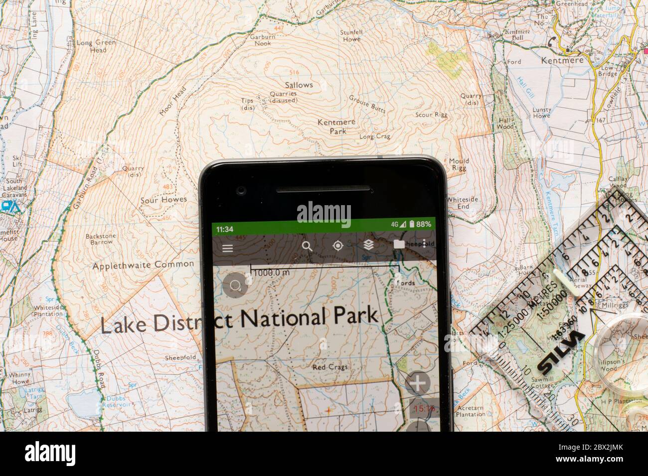 Karte auf Handy-Bildschirm-App mit Papier OS Karte der überlappenden Fläche und Silva Kompass romer. Auswahlkonzept für die Navigation im Freien. Stockfoto