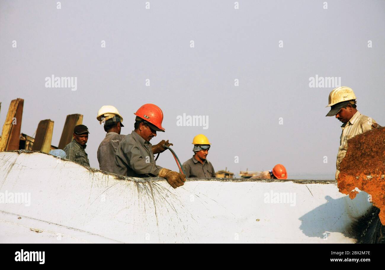 Shipbreaking Yard in Darukhana, Mumbai, Indien – INS Vikrant Abbau mit Schrott & Arbeiter im Hintergrund Stockfoto