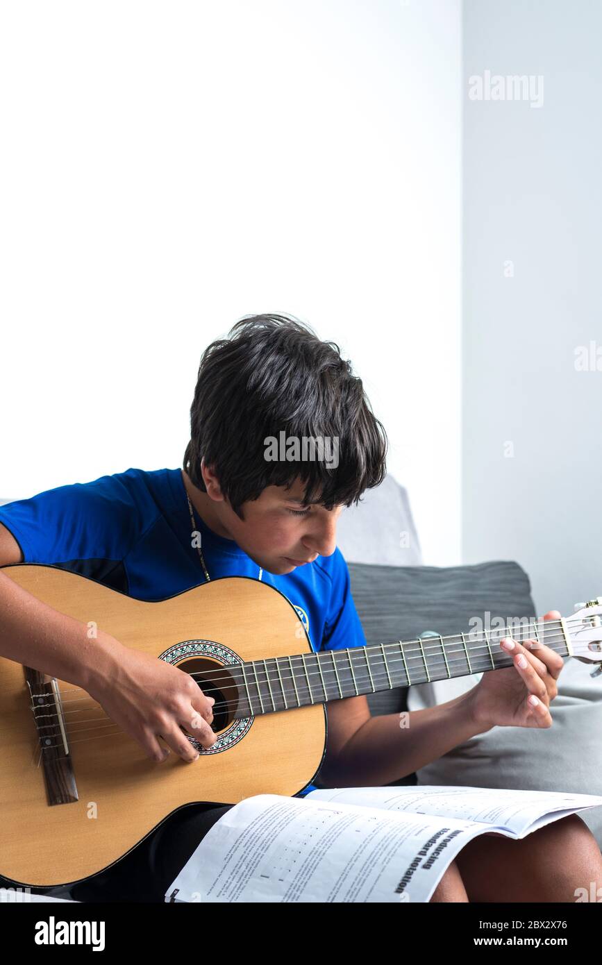 Teenager spielt Gitarre zu Hause Stockfoto