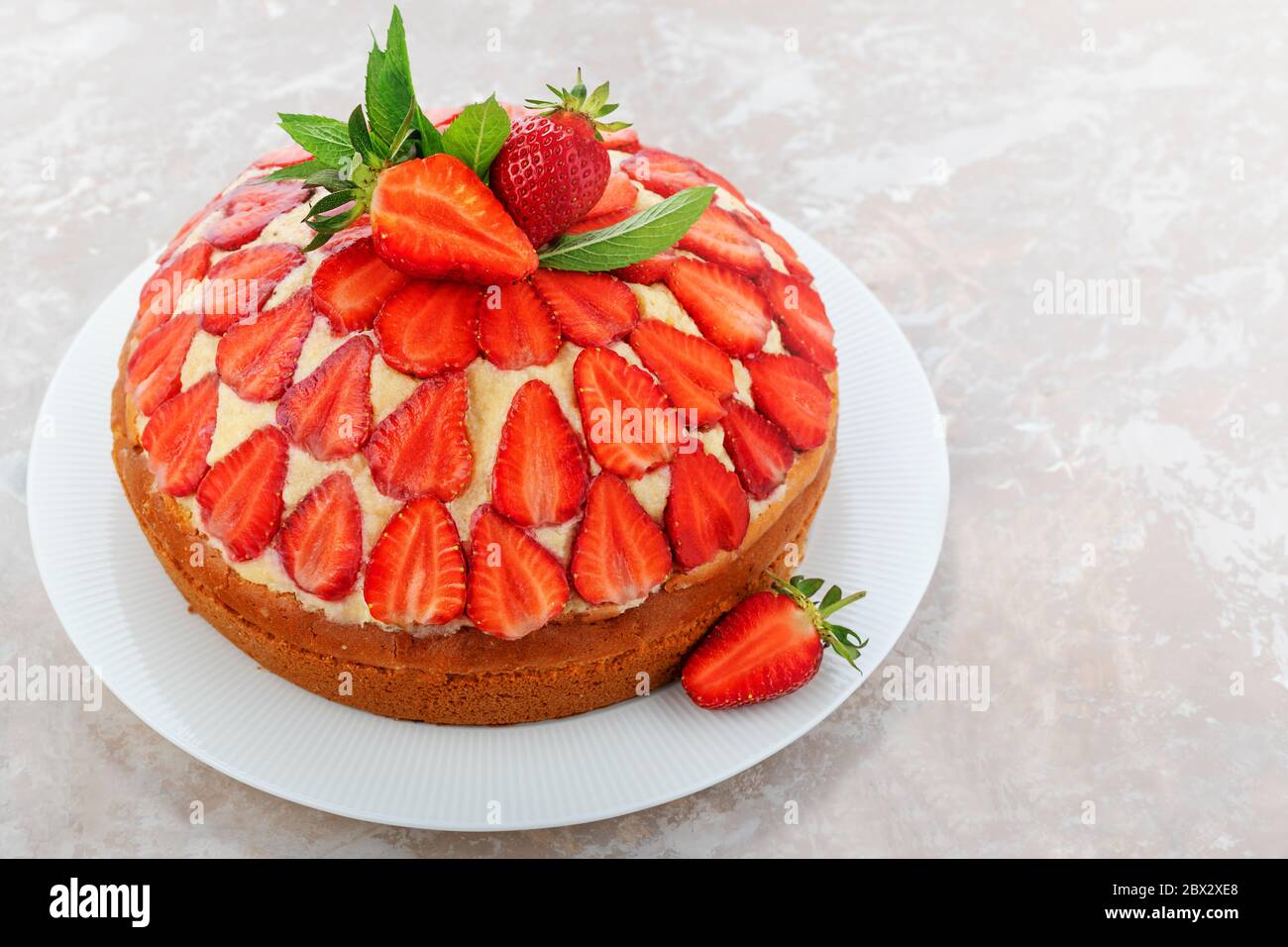 Köstliche Erdbeerkuchen oder Frischkäse Kuchen garniert mit Erdbeeren auf einem hellen Hintergrund. Hausgemachtes Dessert im Sommer. Kopierbereich. Stockfoto