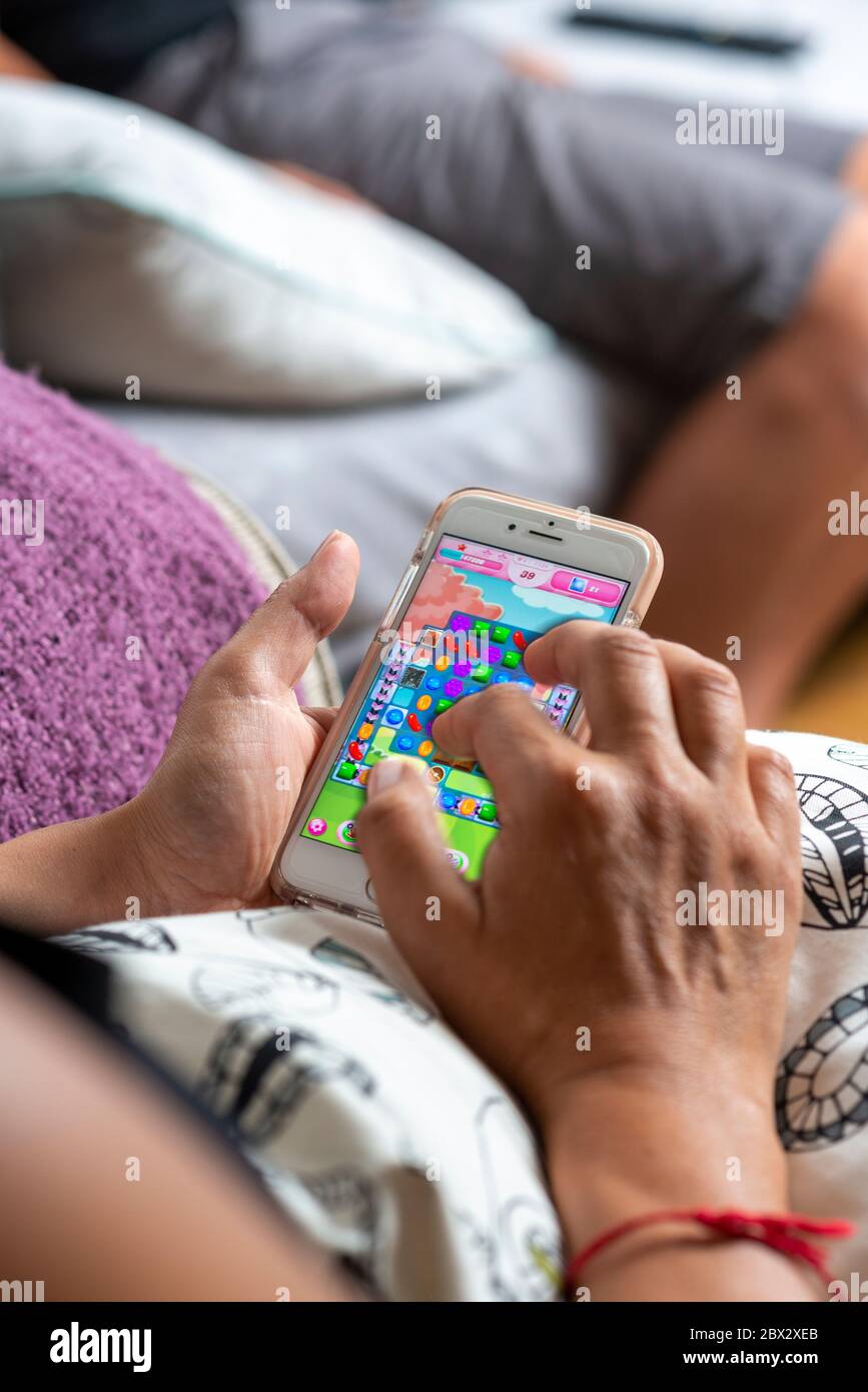 Frau spielt Candy Crush Saga Spiel auf ihrem Handy Stockfoto