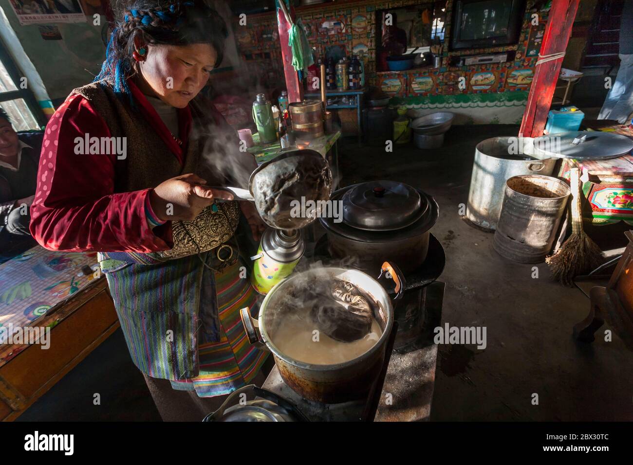 China, Tibet Autonome Region, Tingri, Gästehaus Unterkunft, Frau serviert Yak Butter Tee, Höhe 4300 m Stockfoto