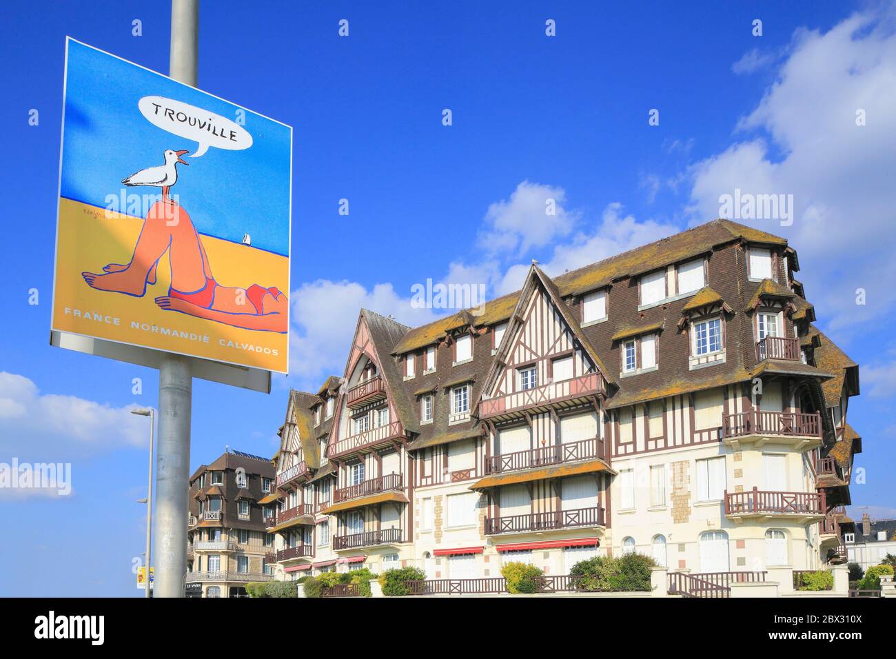 Frankreich, Calvados, Pays d'Auge, Trouville sur Mer, Les Planches Promenade Savignac, Gebäude am Wasser des frühen 20. Jahrhunderts mit einem Plakat, das das Reiseziel von Raymond Savignac bewirbt Stockfoto