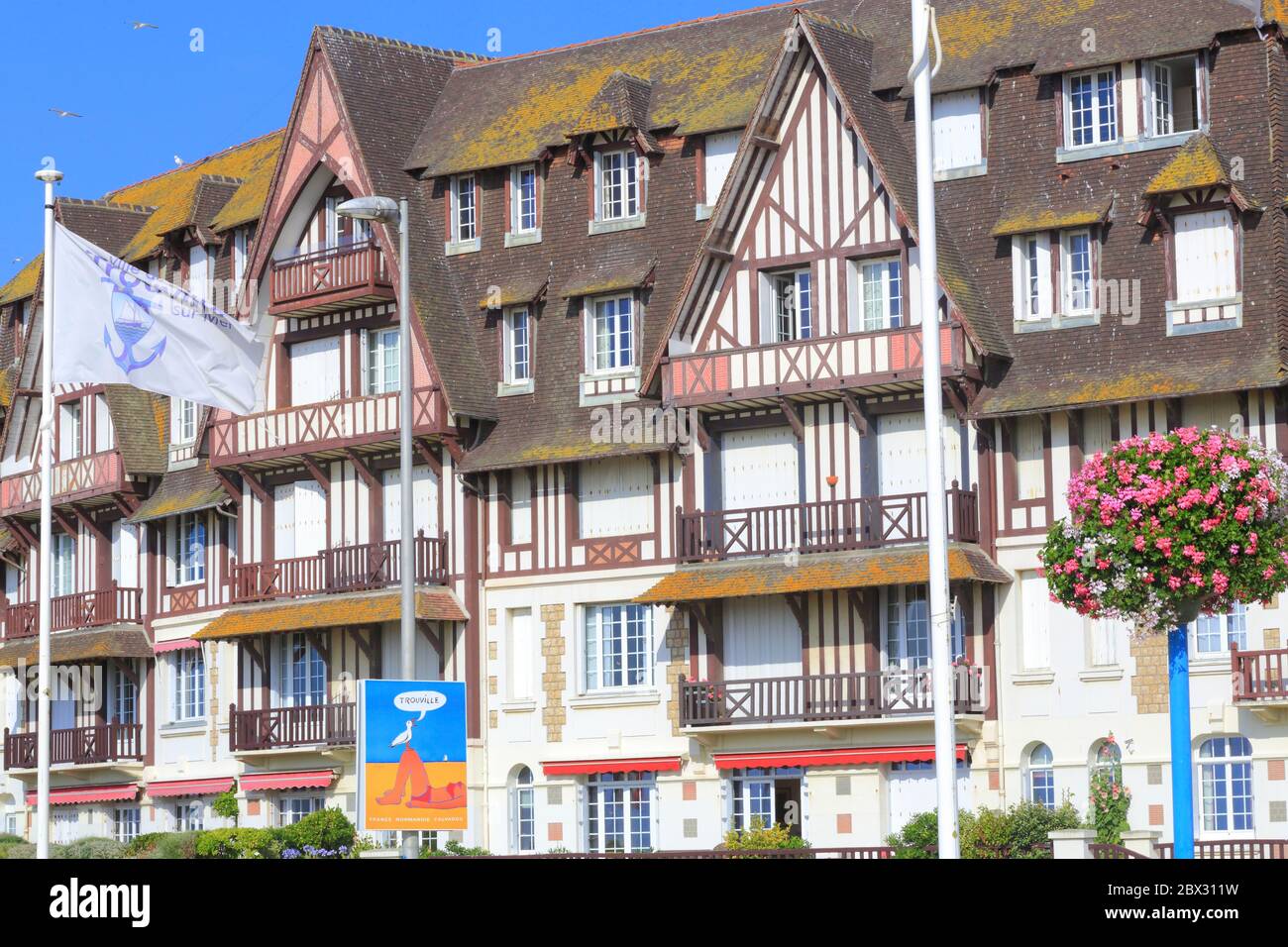 Frankreich, Calvados, Pays d'Auge, Trouville sur Mer, Les Planches Promenade Savignac, Gebäude am Wasser vom Anfang des 20. Jahrhunderts mit einem Plakat, das das Reiseziel von Raymond Savignac bewirbt Stockfoto