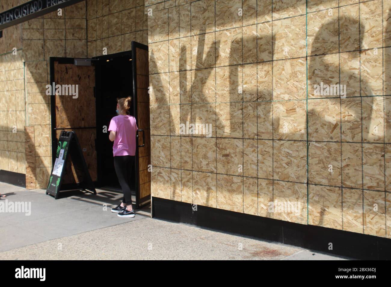 Frau, die nach den Unruhen von 2020 vor einem Restaurant in Chicago stand Stockfoto
