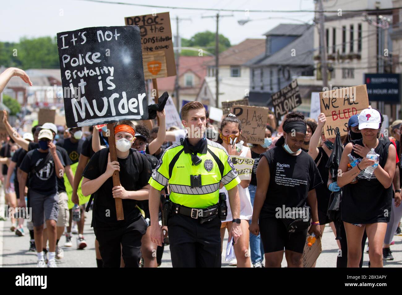 TREDYFRIN, Pennsylvania, USA. Juni 2020. Ein Polizeibeamter schließt sich Protestierenden an, als sie durch Berwyn, PA entlang der Lancaster Avenue marschieren.Quelle: Val Pucci/Alamy Live News Stockfoto