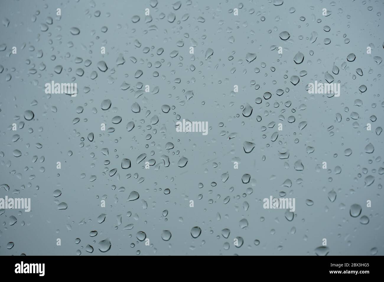 Regen fällt close-up kleben auf die Fensterscheibe in starkem Regenguss mit bewölktem Himmel auf dem Hintergrund Stockfoto