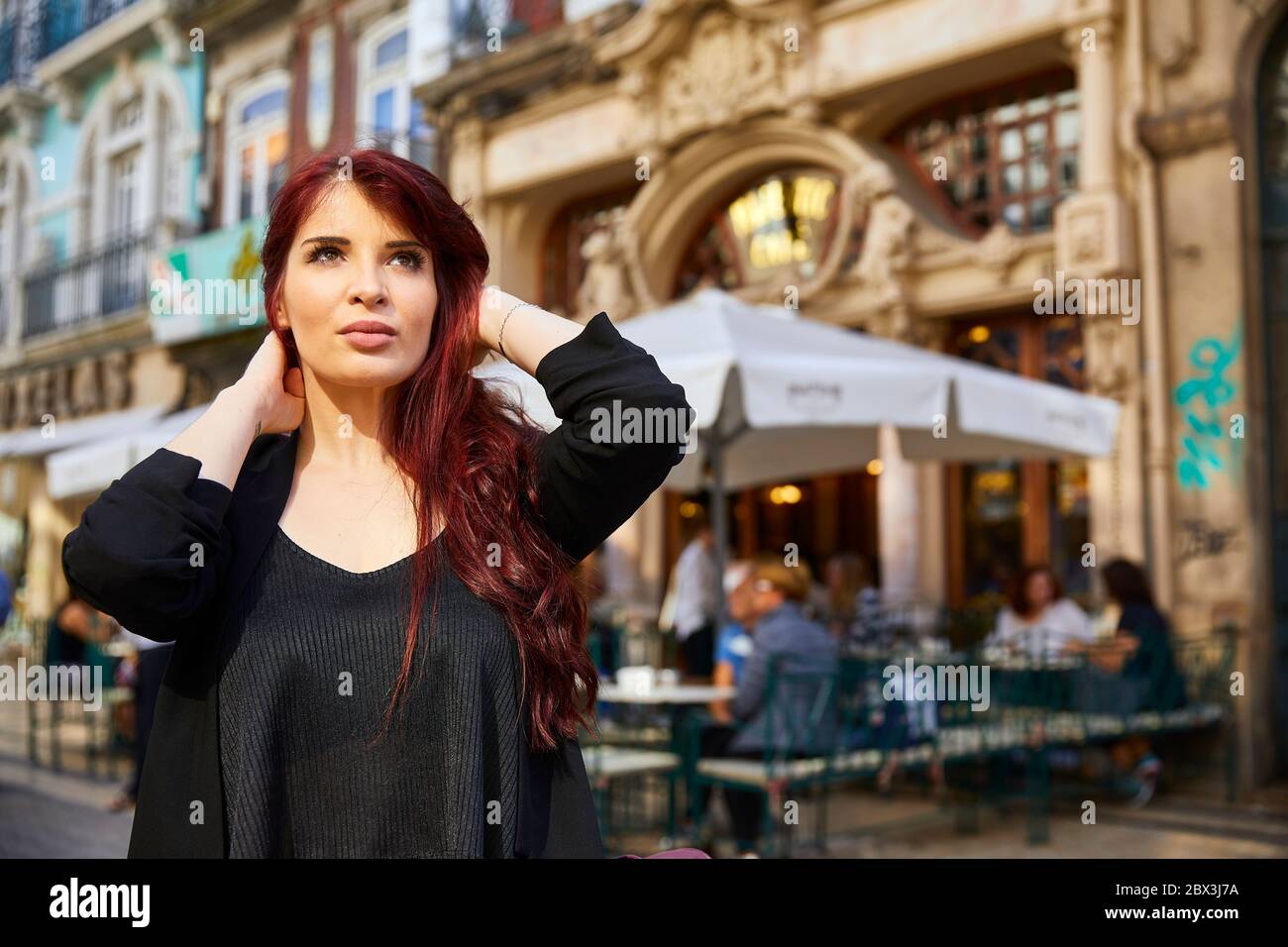 Eine Portugiesin steht vor dem Café Majestic an der Rua de Santa Catarina in Porto, Portugal. Stockfoto