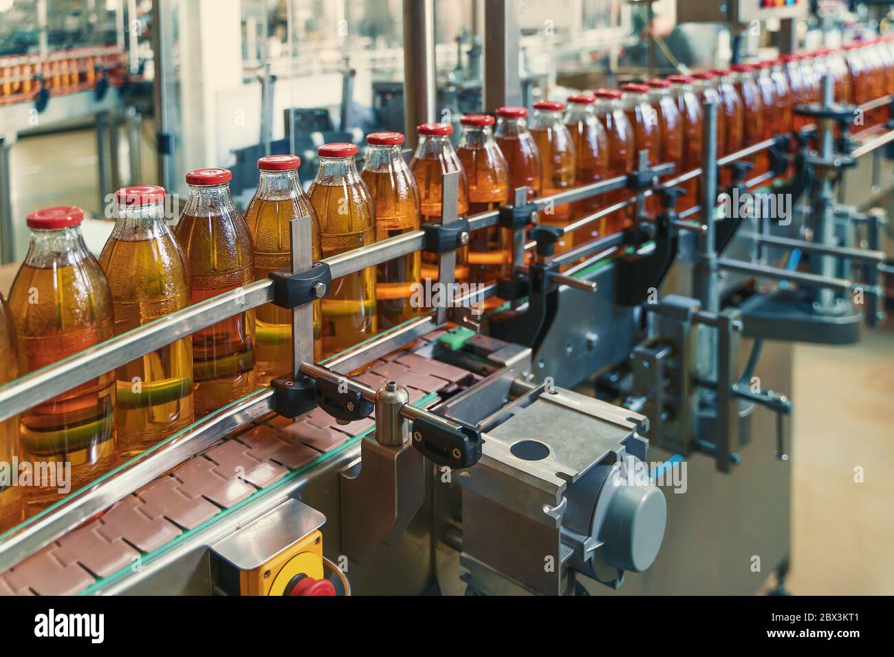 Getränkeherstellung, Herstellung von Lebensmitteln und Getränken, Flaschen mit Saft auf Förderband. Stockfoto