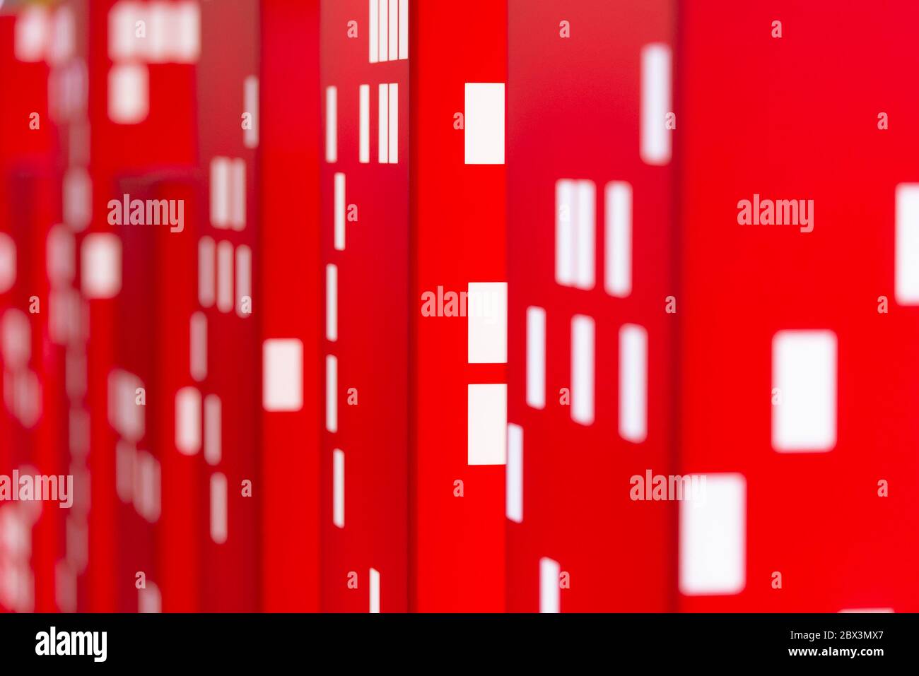 Rote Türme mit weißen Fenstern. Unnatürliche Layouts von Häusern. Abstraktion von Stadthäusern und brennenden Fenstern. Stockfoto