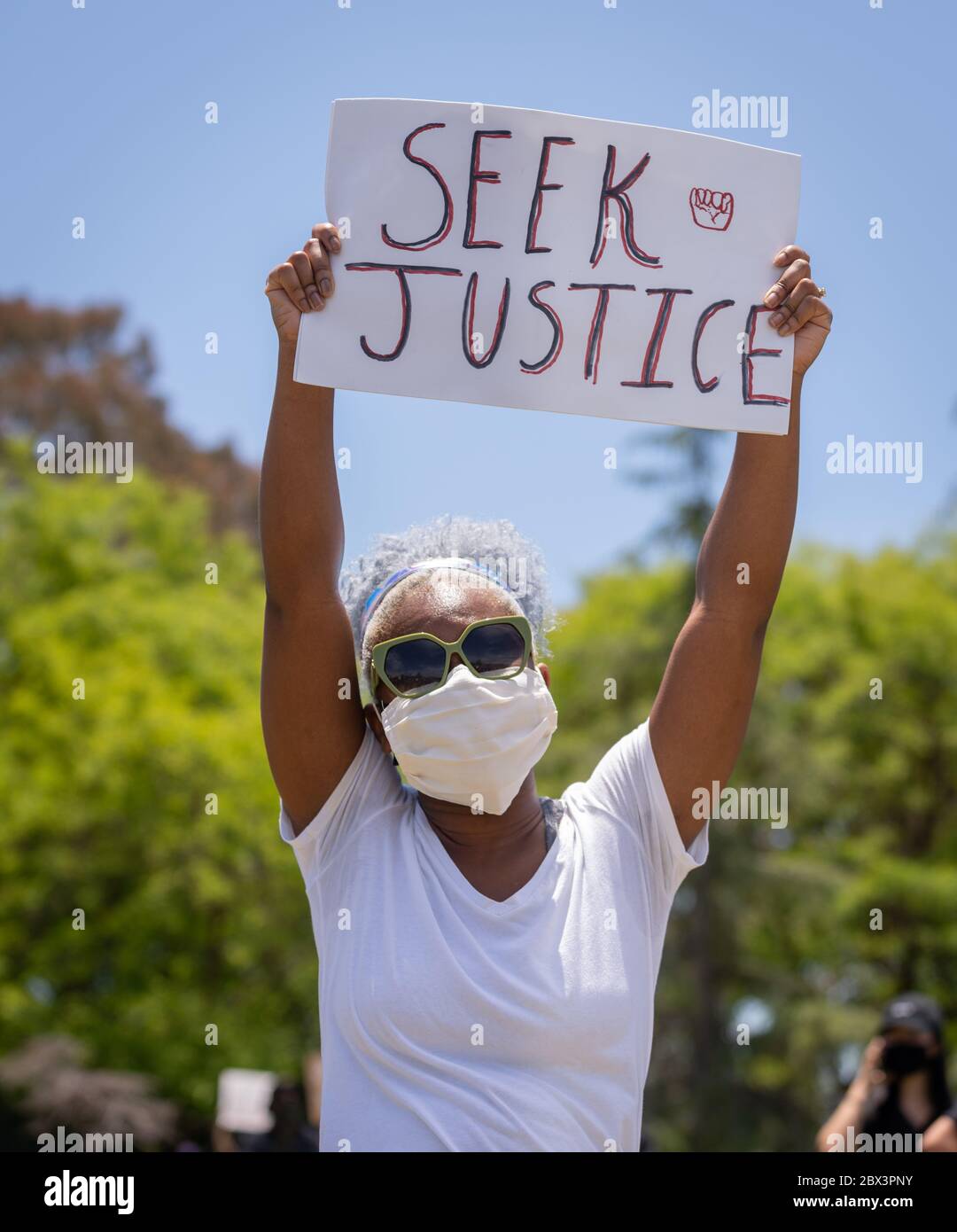 Protestierende mit Schild an der Demonstration zu Ehren von George Floyd, im Pan Pacific Park im Fairfax Viertel von Los Angeles, Kalifornien. Stockfoto