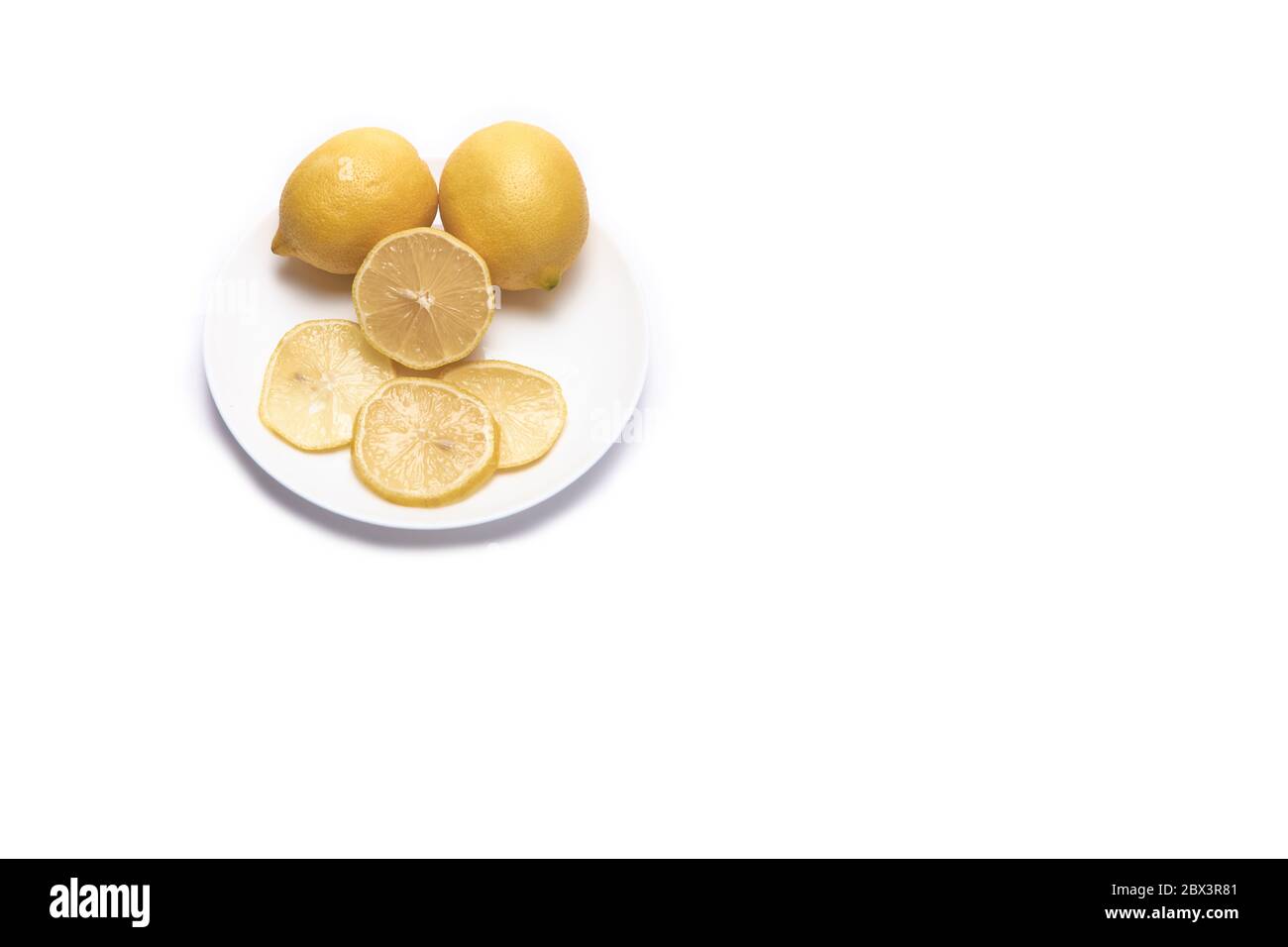Zweieinhalb Zitronen und einige Scheiben auf weißem Hintergrund mit Platz für Text Stockfoto
