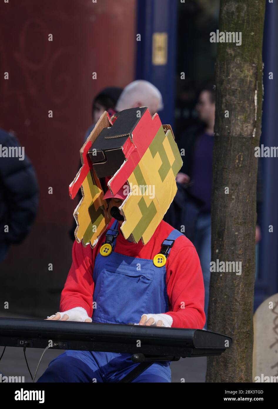 Straßenmusiker auf der Straße als Super Mario Charakter gekleidet. Stockfoto