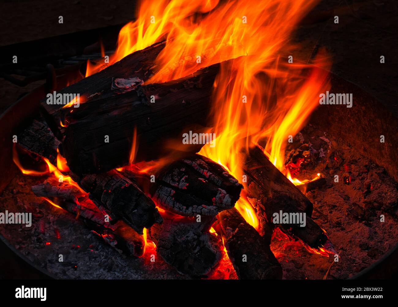 Ein offenes Lagerfeuer in einer runden eisernen Feuerschale Stockfoto