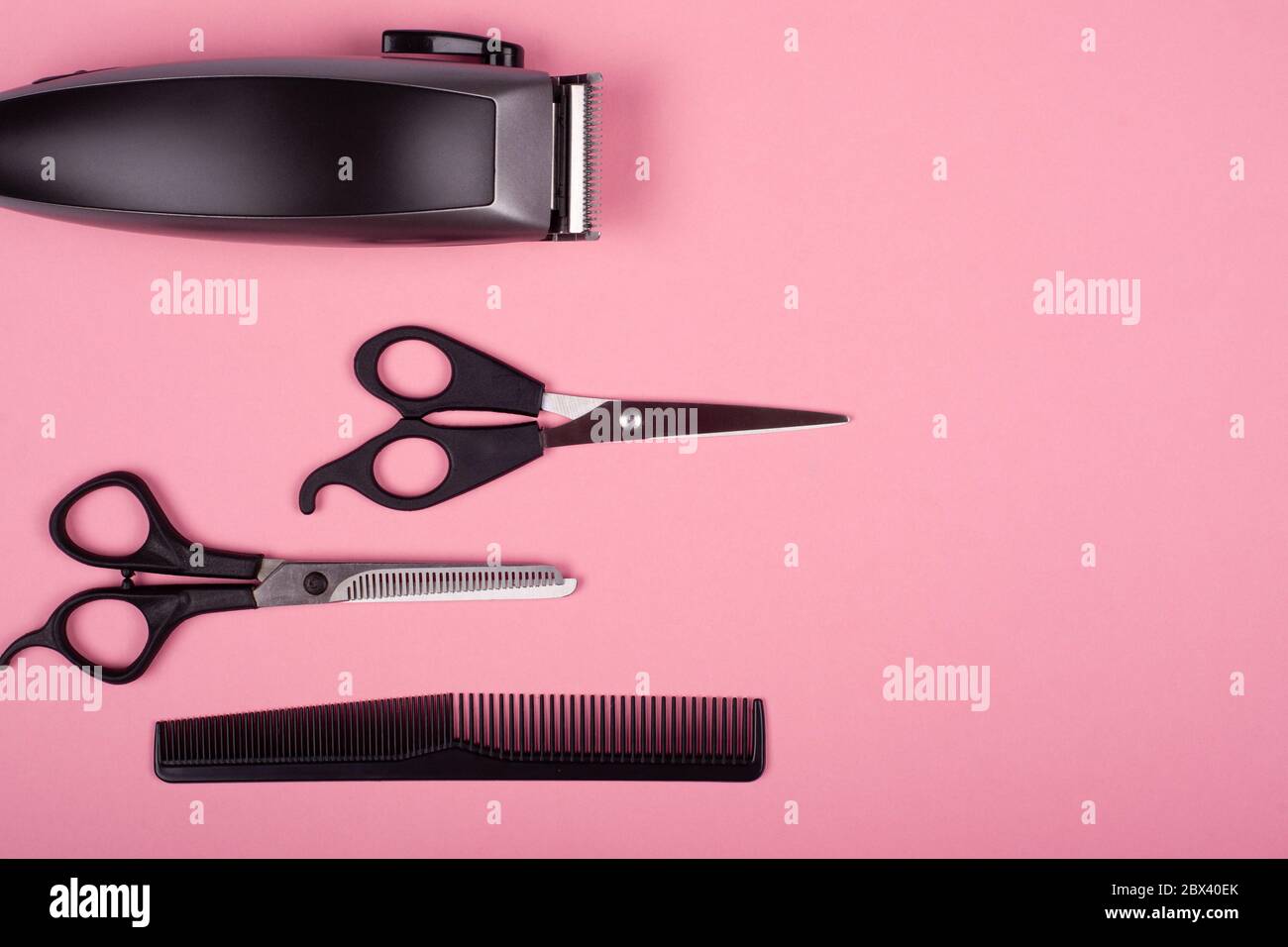 Haarschneider, gerade und dünner Barbier Schere und Kamm auf einem rosa Hintergrund Draufsicht, kopieren Raum. Friseurwerkzeuge. Stockfoto