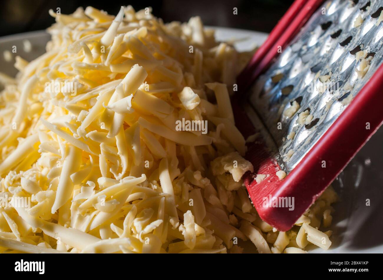 Nahaufnahme oder Makrofotografie von zerfetztem Käse auf einer weißen Platte Stockfoto