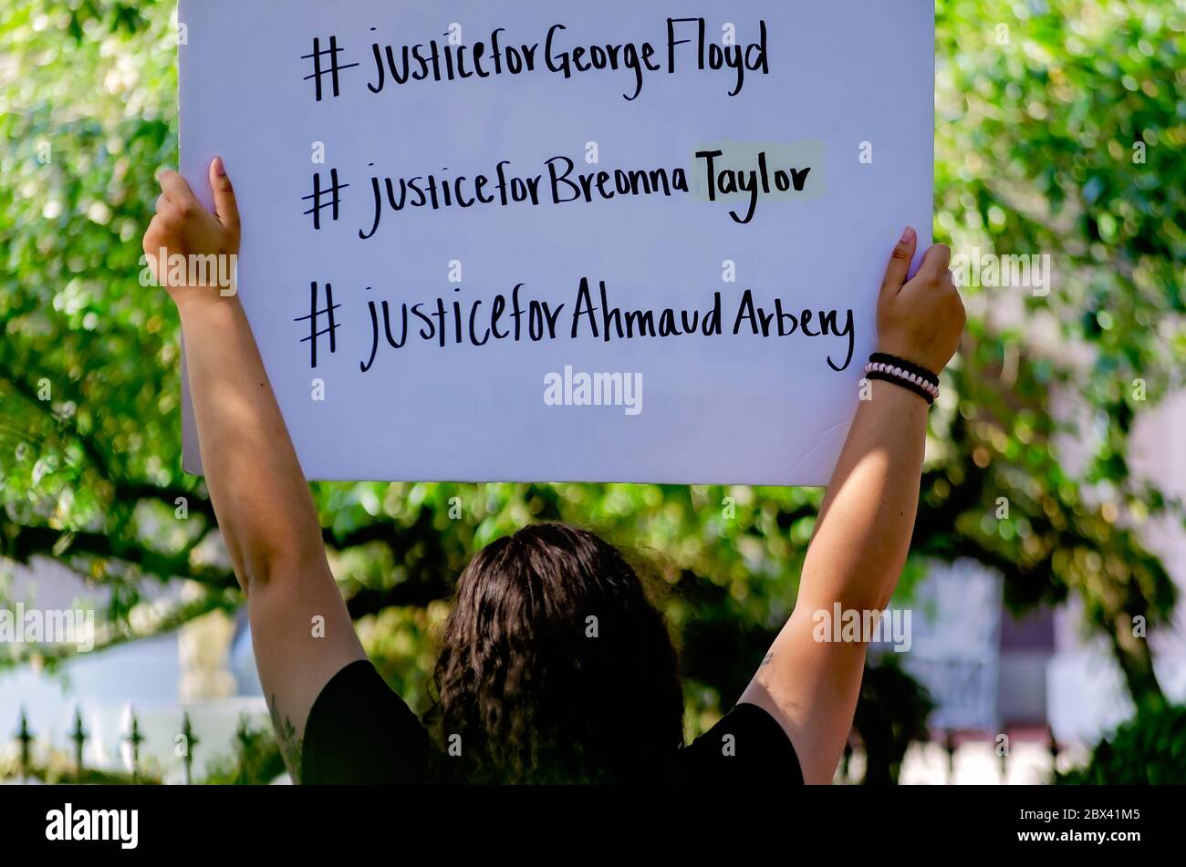 Ein Protestkundgebungsbeamte hält ein Schild hoch, während er am 4. Juni 2020 bei einem Protest gegen die Polizeigewalt im Memorial Park in Mobile, Alabama, protestierte. Stockfoto