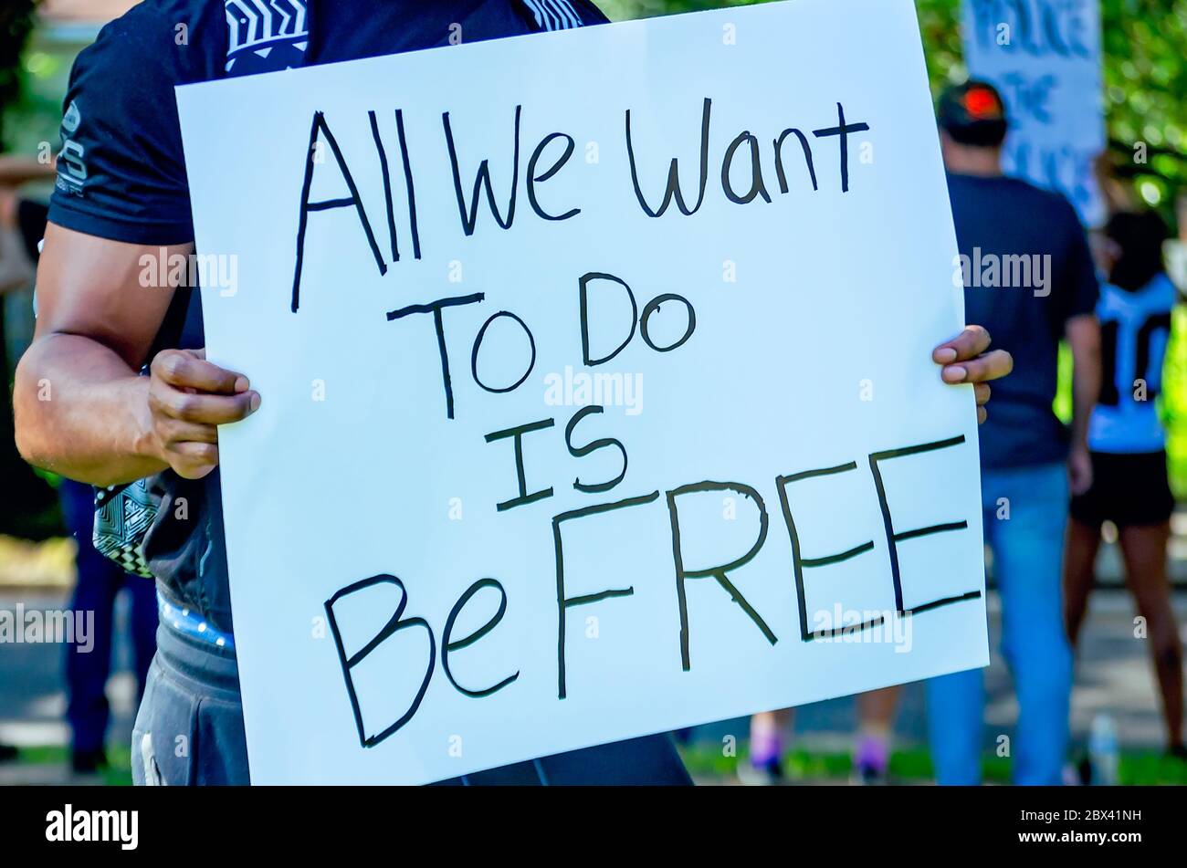 Ein Protestkundgebungsbeamte hält ein Schild, während er am 4. Juni 2020 bei einem Protest gegen die Polizeigewalt im Memorial Park in Mobile, Alabama, protestierte. Stockfoto