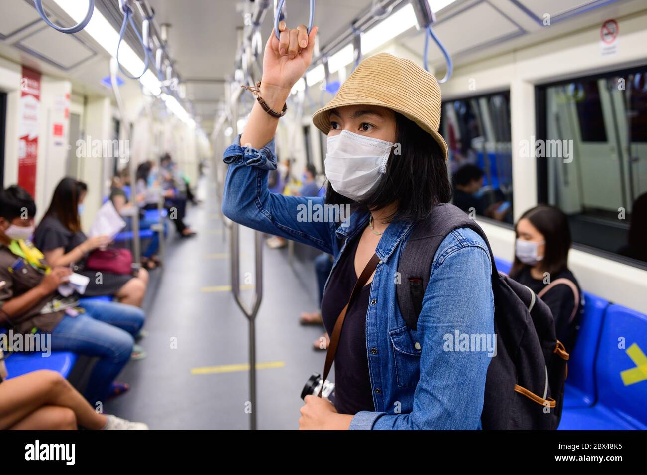 Asiatische Frau trägt Einweg medizinische Gesichtsmaske in der U-Bahn-Zug in Bangkok Stockfoto
