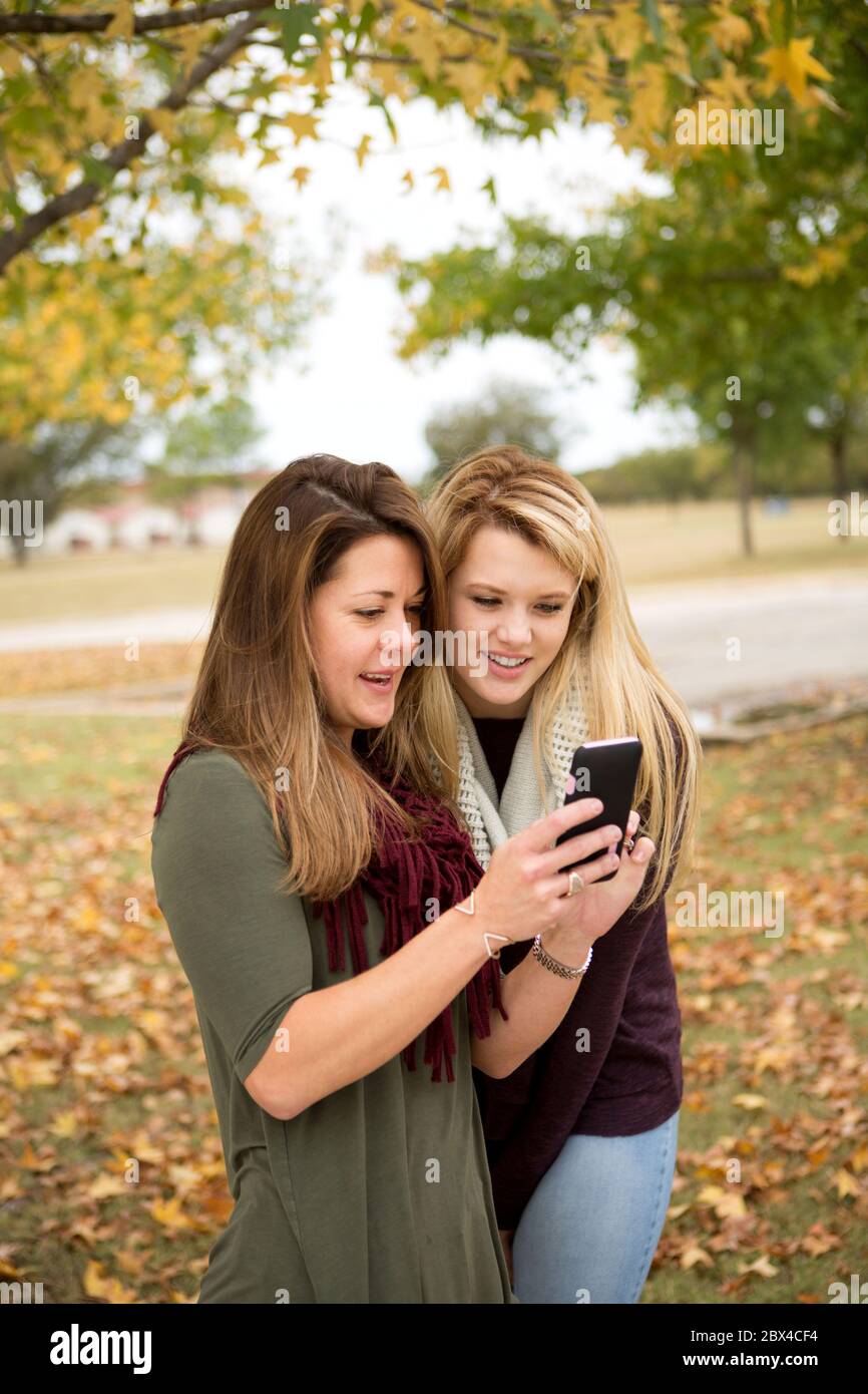 Frau SMS und reden draußen im Herbst. Stockfoto