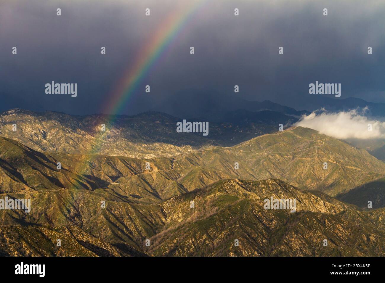 Ein Regenbogen durchschneidet die Wolken in den San Gabriel Mountains im Süden Kaliforniens Stockfoto