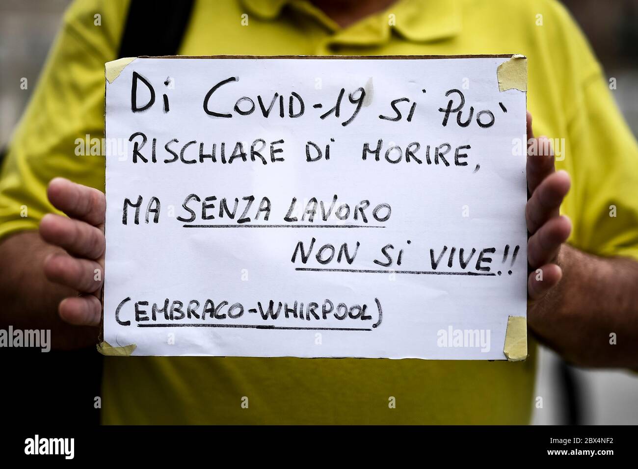 Turin, Italien - 04. Juni 2020: Ein Protestler hält ein Plakat mit der Aufschrift "Wegen Covid-19 kann man sterben, aber ohne Arbeit lebt man nicht" während eines Protestes von ehemaligen Embraco-Arbeitern (Whirlpool-Gruppe), die sich über unbezahlte Rückzahlungen von Ventures beschweren. Whirlpool verkaufte Riva di Chieri Werk an Ventures am 2018. Juli. Quelle: Nicolò Campo/Alamy Live News Stockfoto