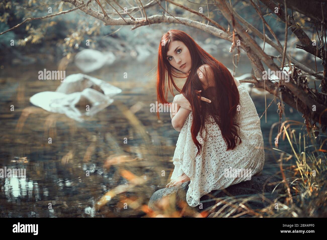 Schöne Frau posiert auf einem Bach Ufer. Herbstfarben Stockfoto