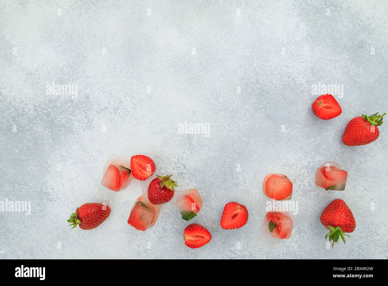 Erdbeere mit isoliertem auf grauem Hintergrund. Flaches Lay. Draufsicht. Sommer süße Beeren mit Eis Stockfoto