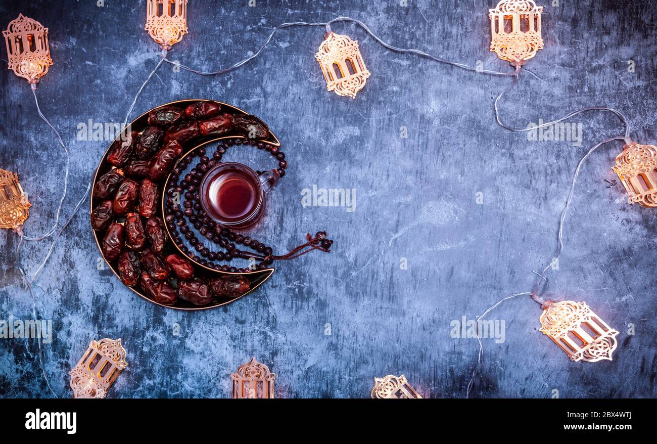 Ramadan und Eid Dekoration Bild, Datteln in einem Mond-förmigen Teller mit türkischem Tee und Tashbi islamischen Iftar und Eid Al Adha Konzept Hintergrund Stockfoto