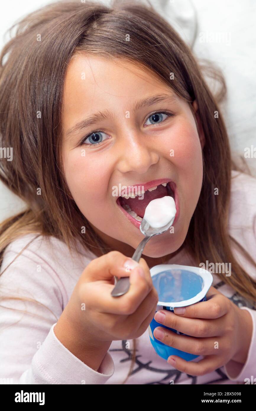 Sechs Jahre altes Mädchen, das Joghurt isst. Stockfoto