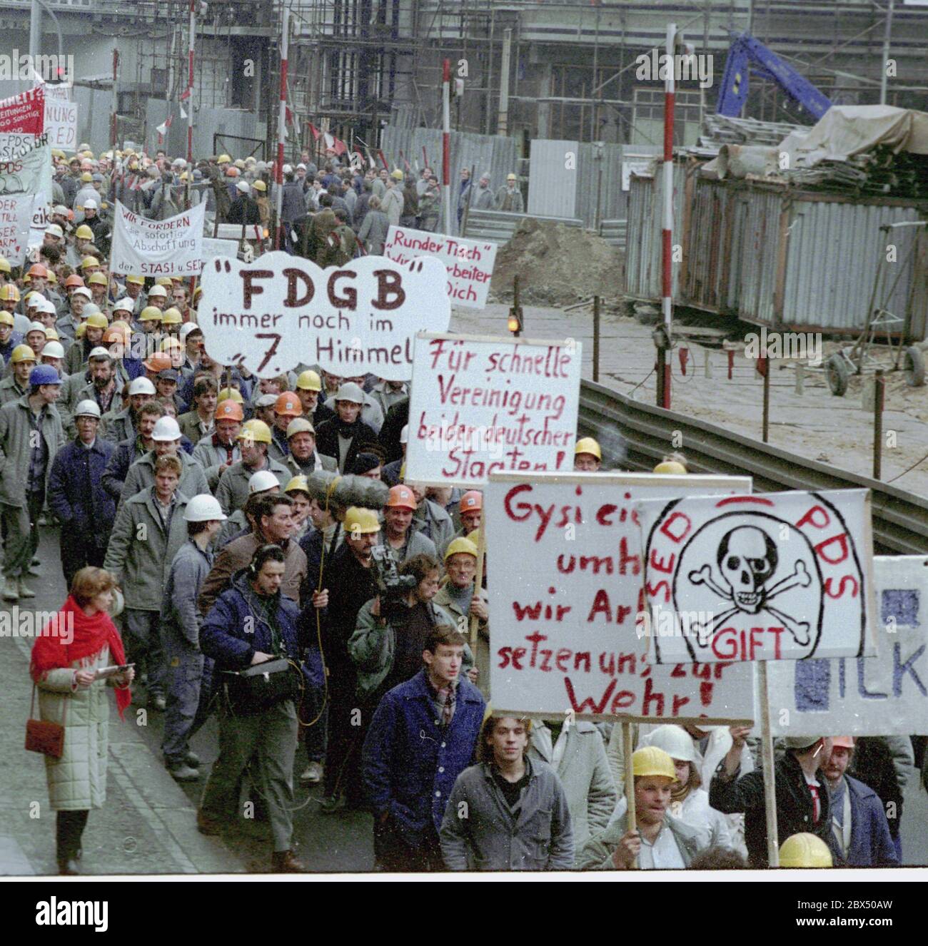 Berlin / DDR / 1990 Bauarbeiter der Friedrichstraße marschieren in die Volkskammer. Hier: Unter den Linden. Der Runde Tisch hat Schwierigkeiten mit der Regierung Modrow (SED/PDS). Sie wollen Druck ausüben. Forderung: Wir wollen die Wiedervereinigung. -Keine Stasi, keine SED, sonst verabschiede ich mich von der DDR -der protestmarsch unter den Linden Forderungen: -Wir wollen Wiedervereinigung. -die SDP/SPD war stark in der Firma Ingenieur-hoch-Bau. Einer der Organisatoren war Knut Herbst, Abgeordneter des landtags in Berlin der Mittelträger (schwarze Jacke) ist Ralf Hillenberg, SPD-Politiker / Runde Stockfoto