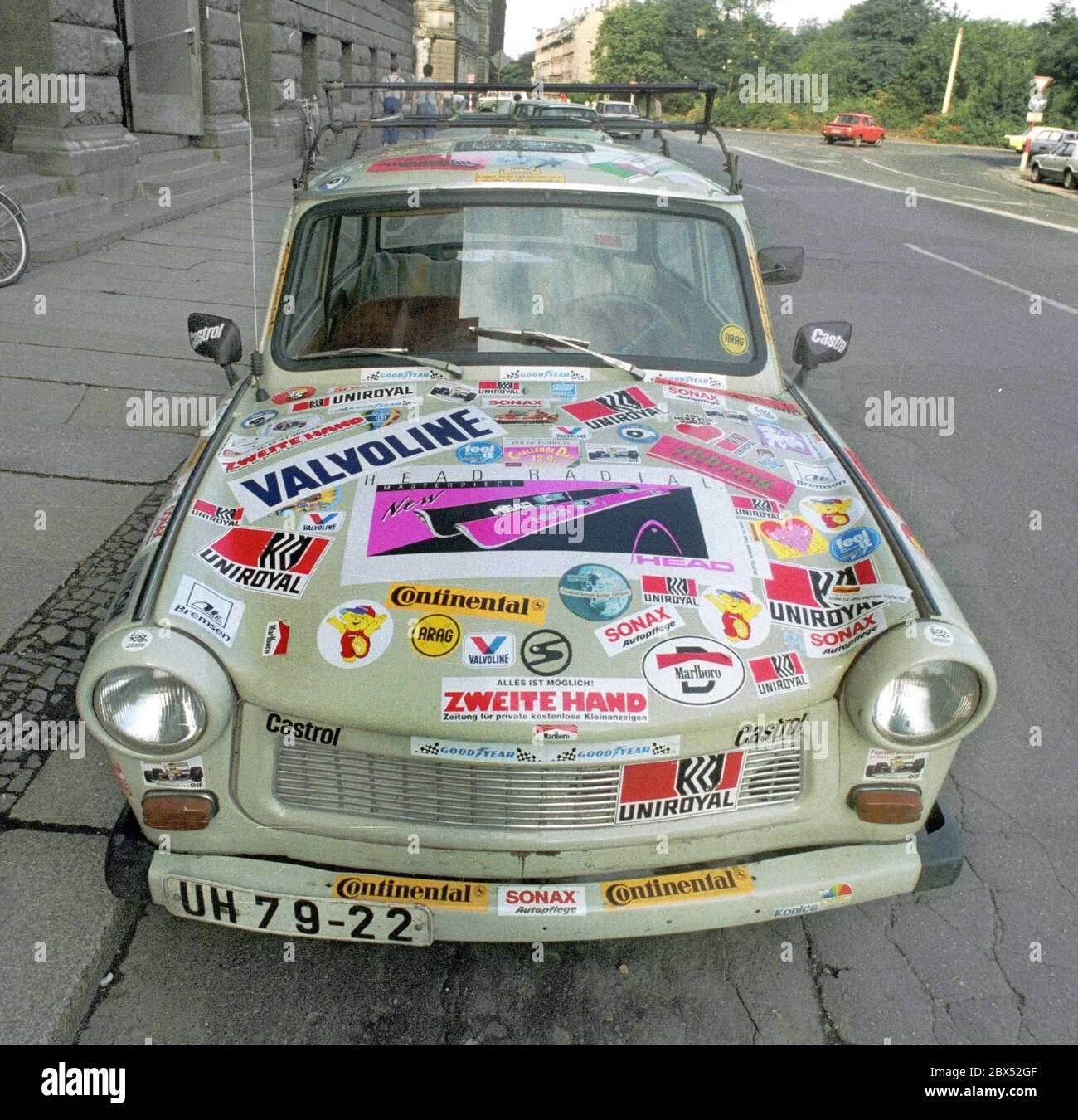 DDR-Land / Sachsen / Bundesländer / 1990 Leipzig Innenstadt. Die DDR existiert noch, aber dieser Trabant hat bereits die Vereinigung mit viel westlicher Werbung vorweggenommen. // Auto / Einheit / [automatisierte Übersetzung] Stockfoto