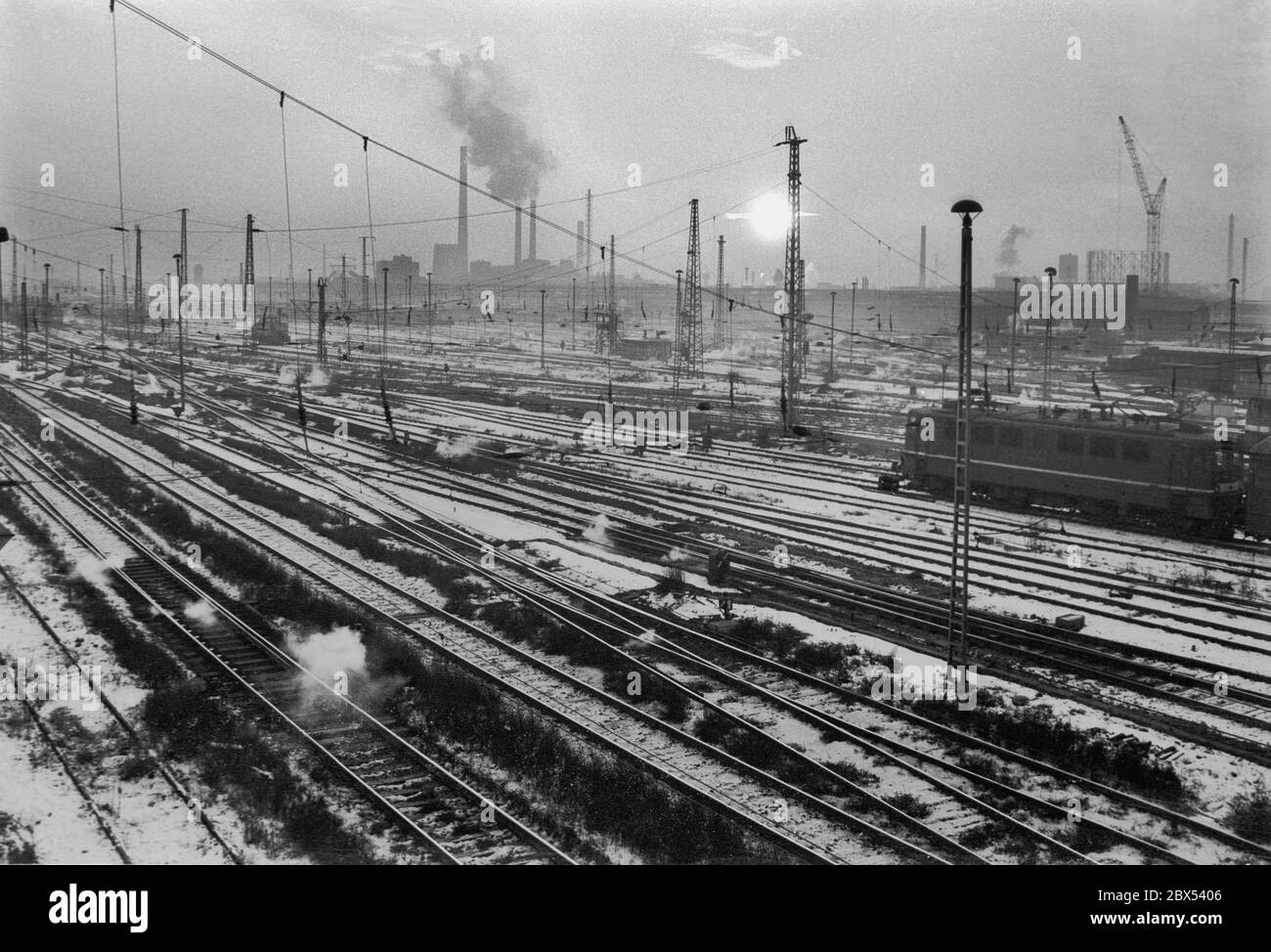 Sachsen-Anhalt / DDR / Winter / Dezember 1989 Winterabend in Bitterfeld, Sonnenuntergang hinter dem Braunkohlekombinat, Bahngelände vor // Stimmung / Wirtschaft / Vertrauen / Industrie / [automatisierte Übersetzung] Stockfoto